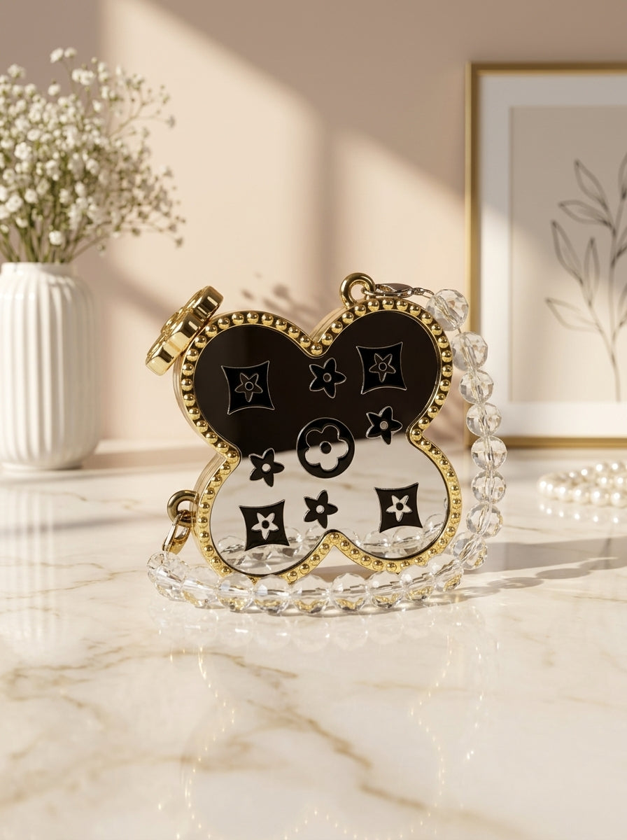 Gold four-leaf clover monogram evening clutch with black enamel and rhinestone chain strap