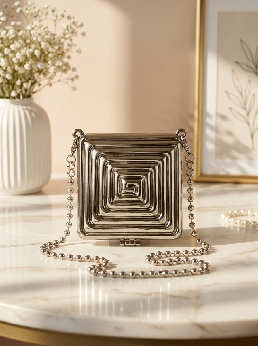 Silver geometric spiral clutch with hinged flap and beaded shoulder chain