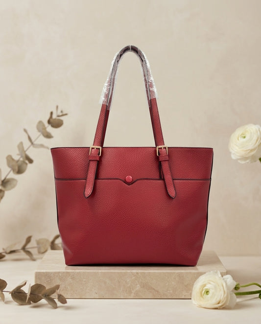 Pebbled faux leather pocket tote bag in red with buckle strap handles and front pocket