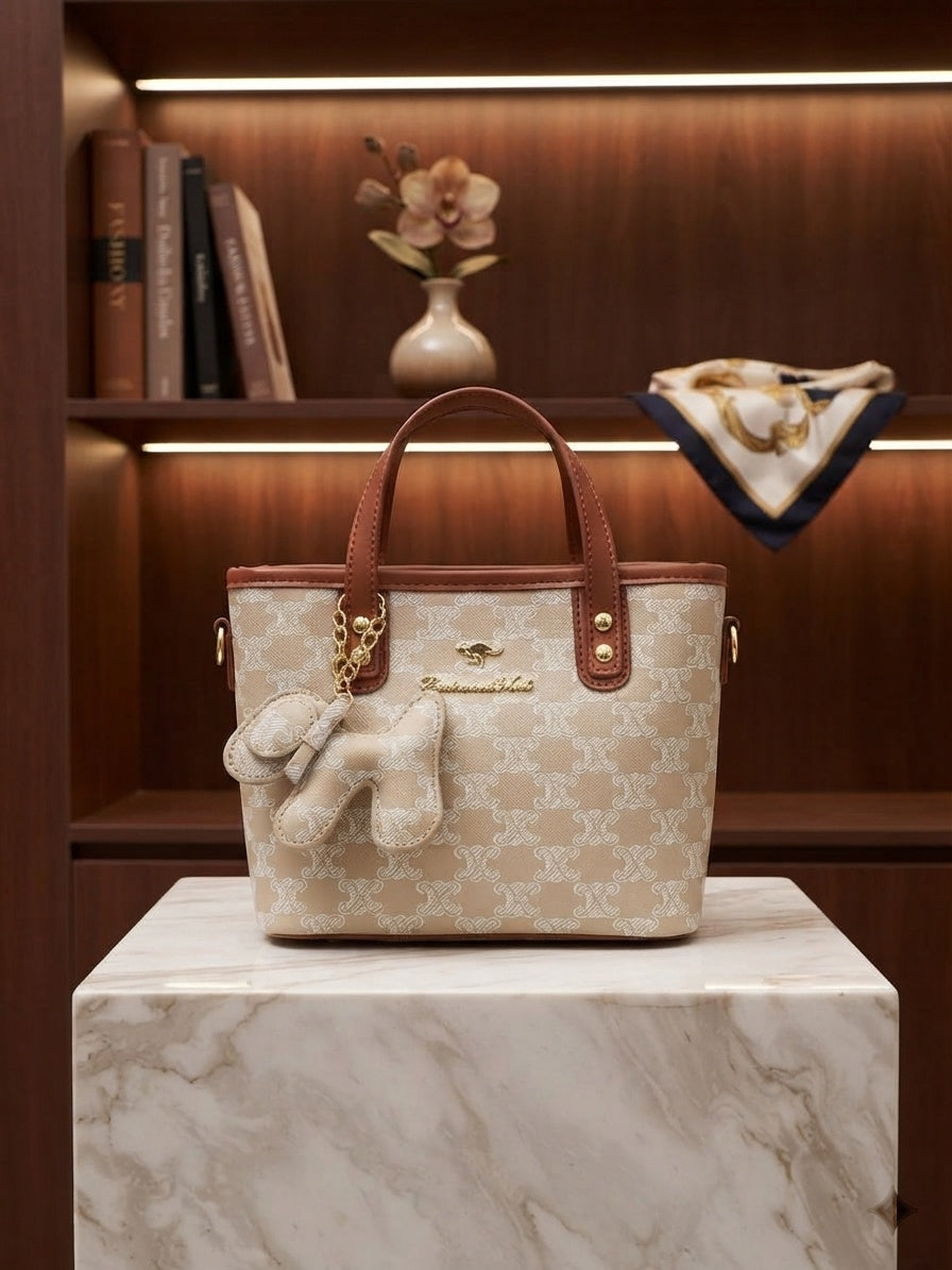 Beige monogram print structured tote bag with tan handles and animal charm