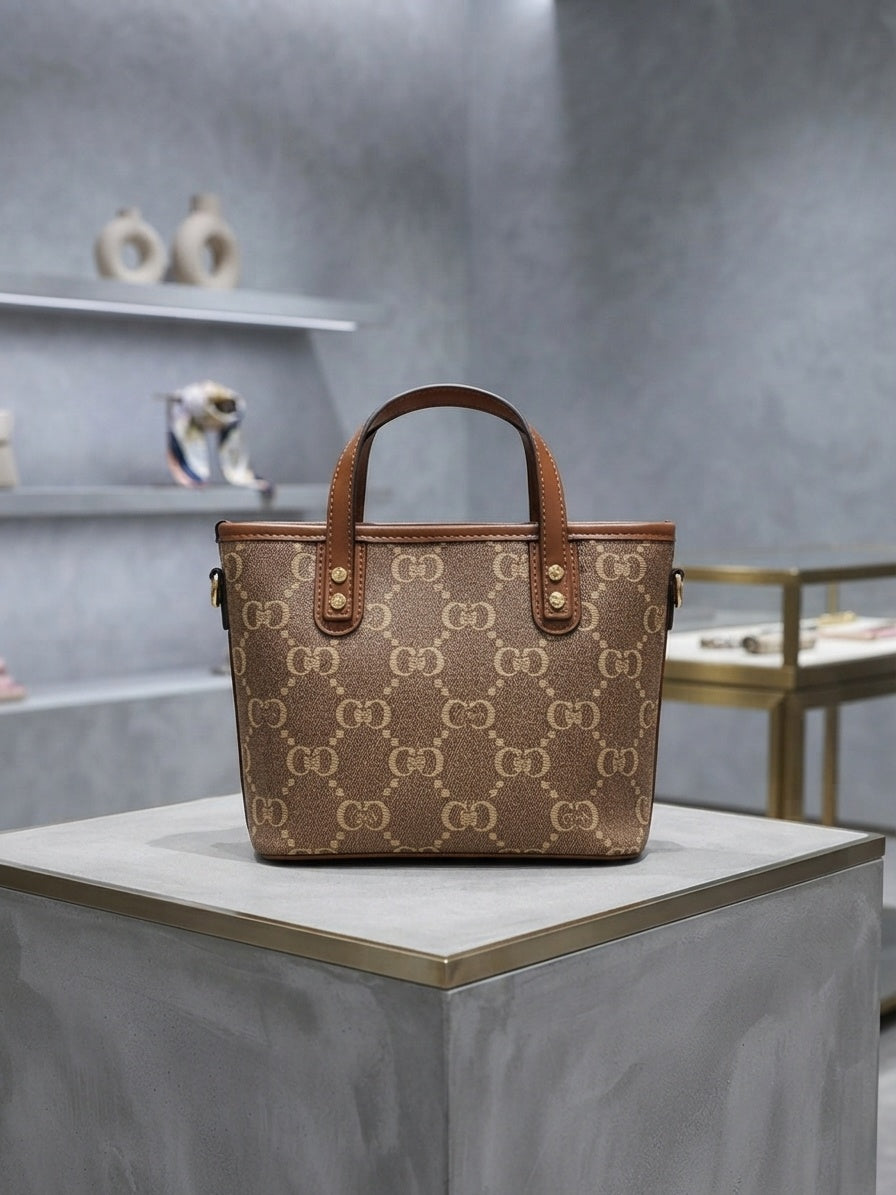 Structured monogram tote bag, brown and tan, with top handles and animal charm