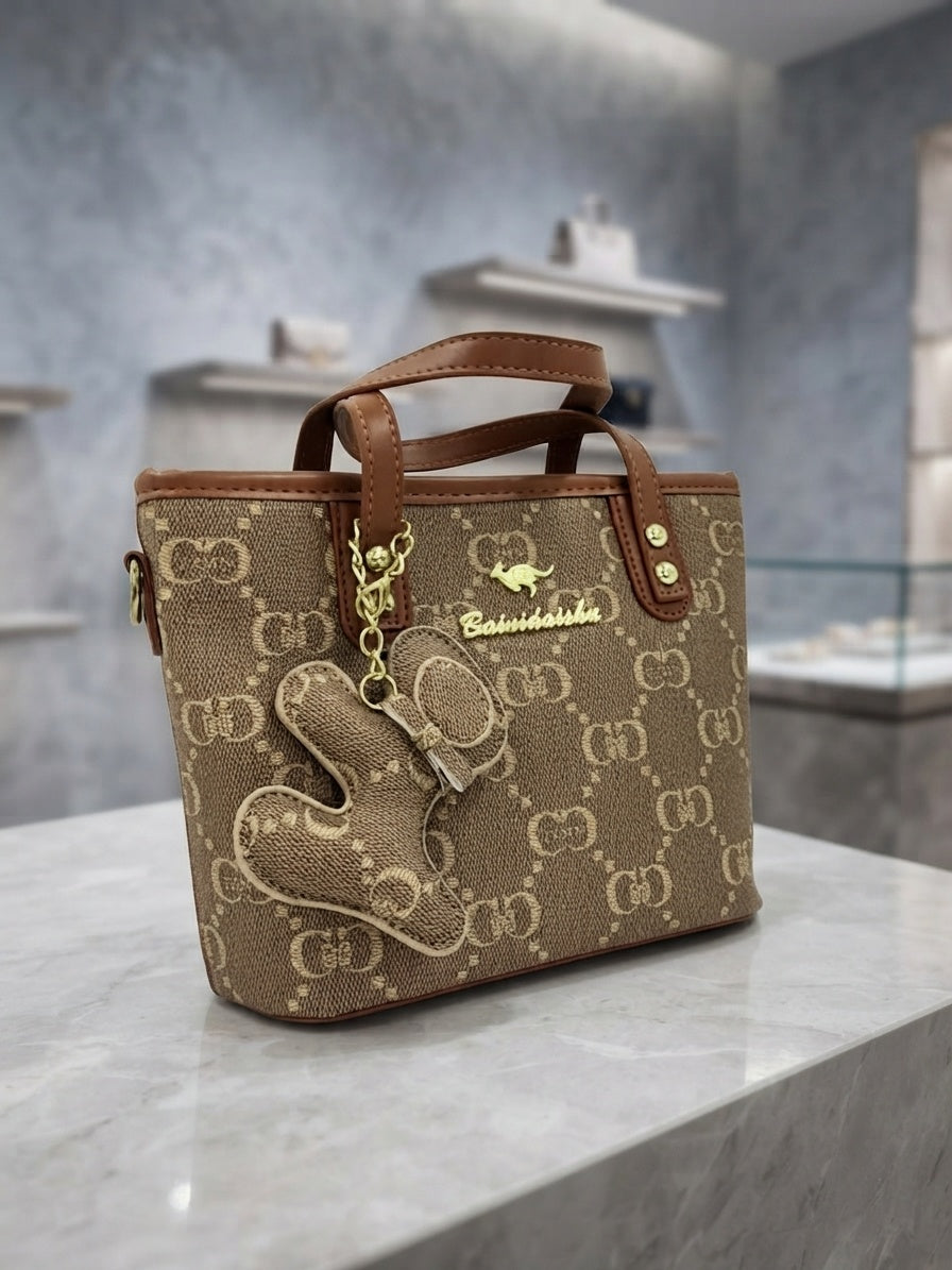 Brown and tan monogram structured tote bag with front animal charm and leather trim