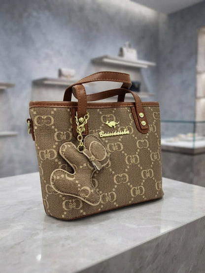 Brown and tan monogram structured tote bag with front animal charm and leather trim
