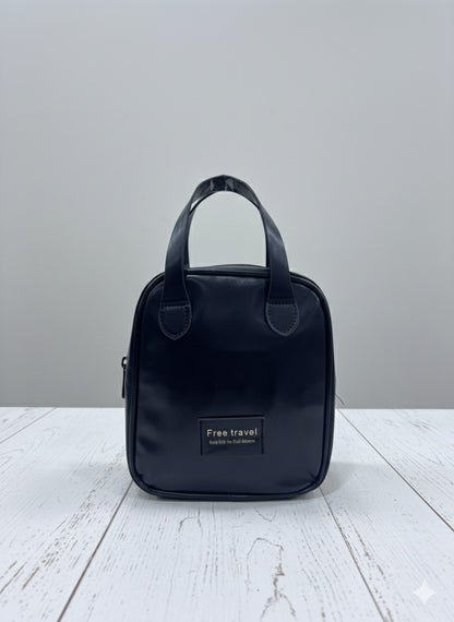 Dark blue leather-look makeup bag with top handle and front logo patch
