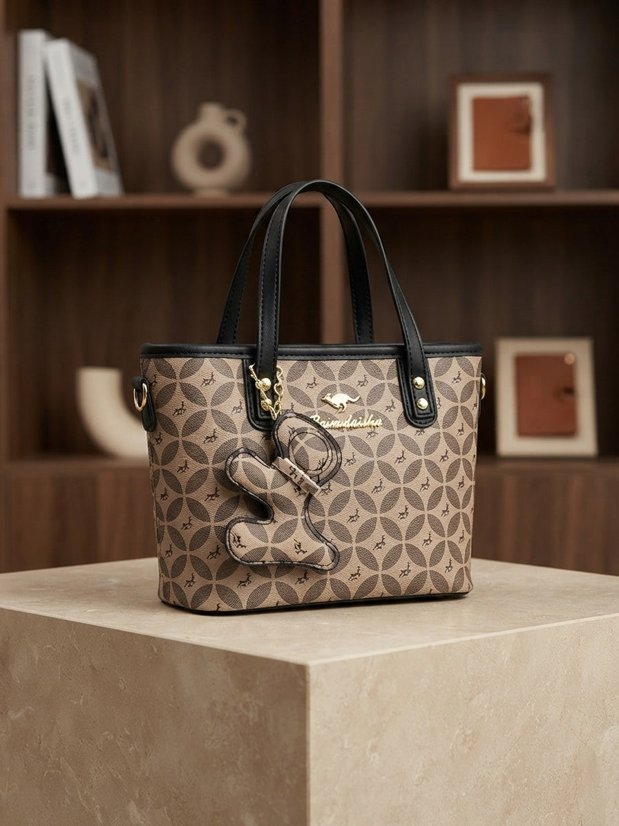 Structured tote bag with geometric monogram pattern, black handles, animal charm