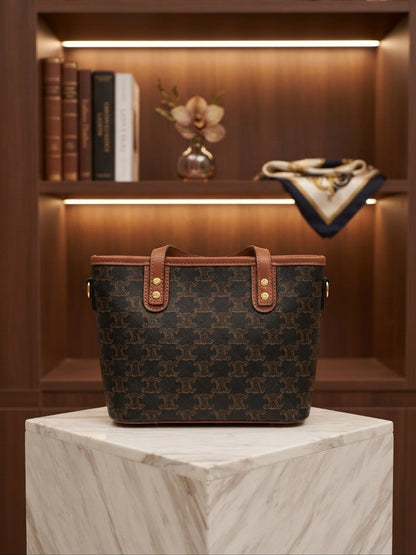 Structured tote bag with dark monogram print, tan leather handles, animal charm