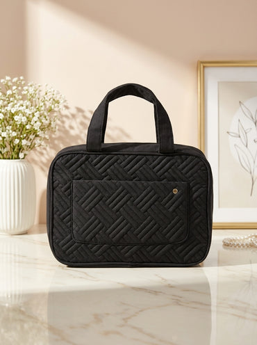 Black quilted hanging toiletry organizer bag with top handle and front zip pocket