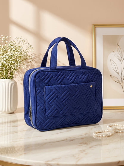 Navy blue quilted hanging toiletry organizer bag with top handle and front zip pocket