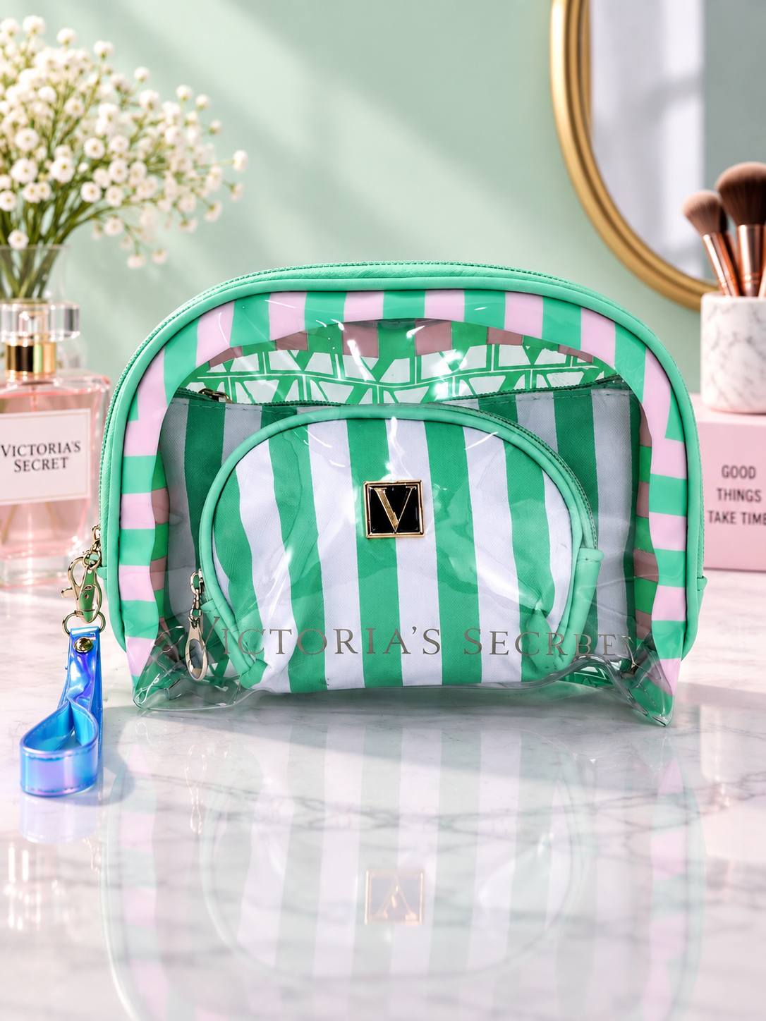 Green and white striped cosmetic organizer with clear zip pouches and V logo patch