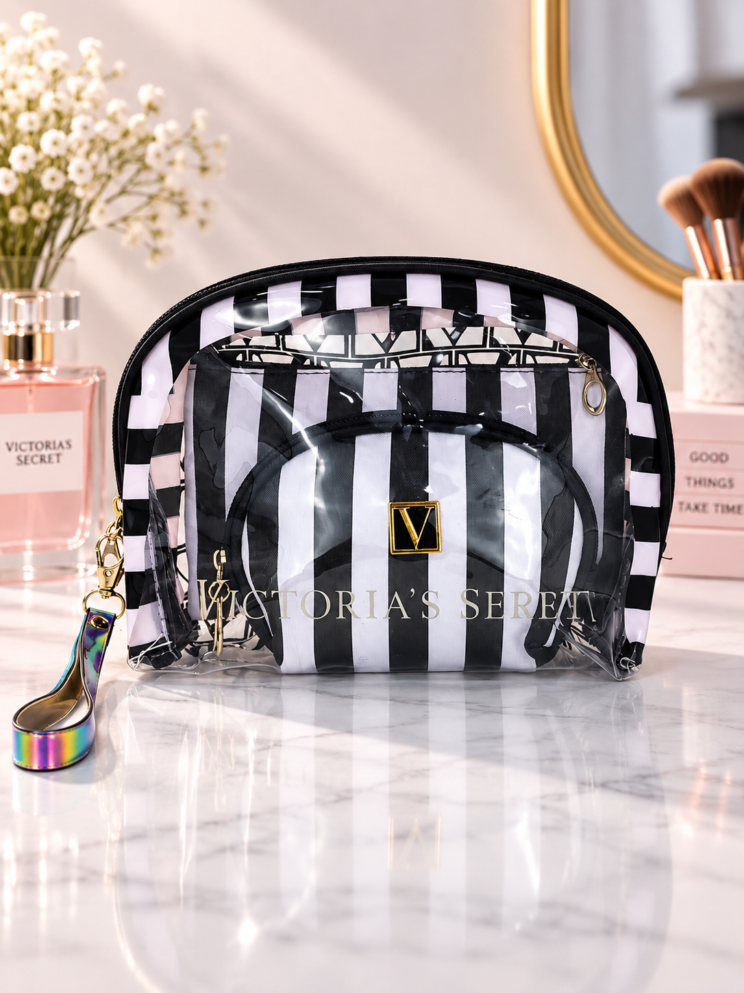Black and white striped cosmetic organizer with clear zip pouches and V logo patch