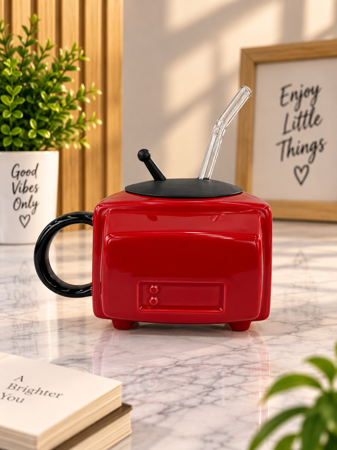 Red ceramic TV-style mug with black handle and straws on the lid
