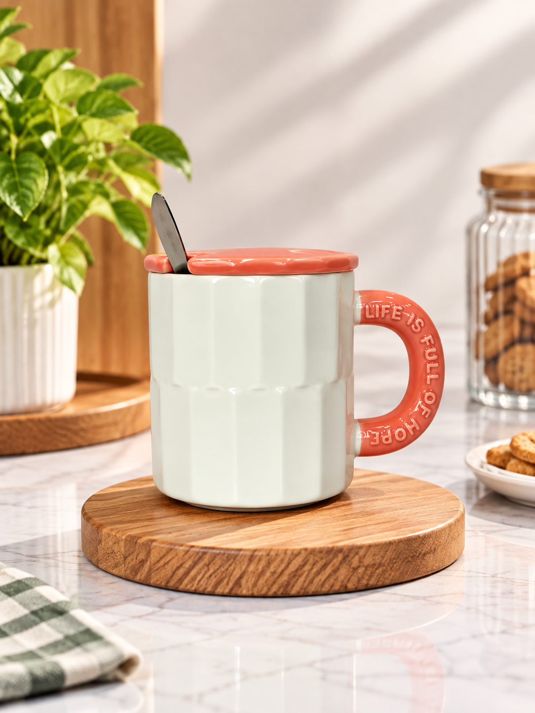 White fluted ceramic mug with orange lid and spoon.