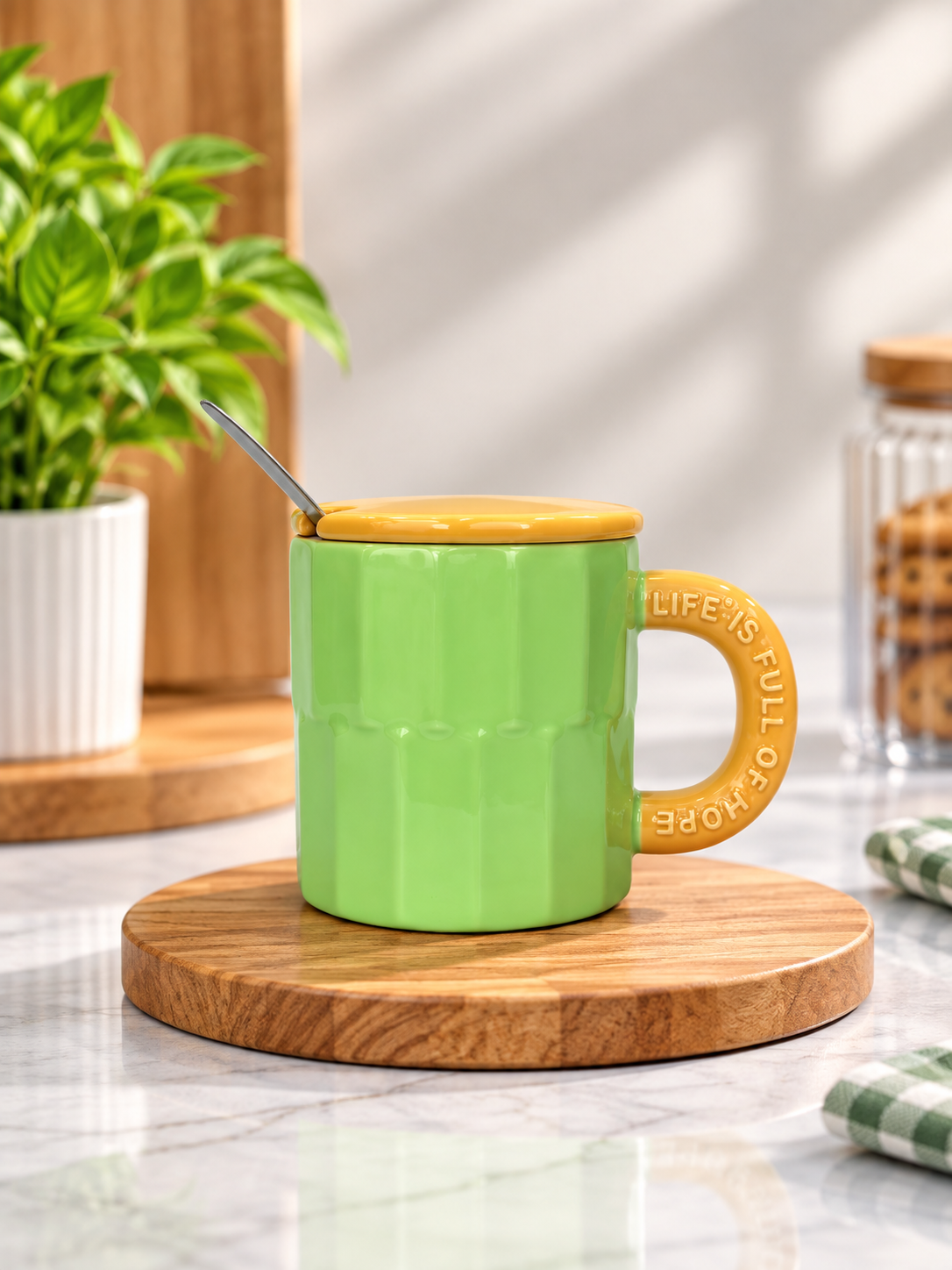 Green fluted ceramic mug with yellow lid and spoon.