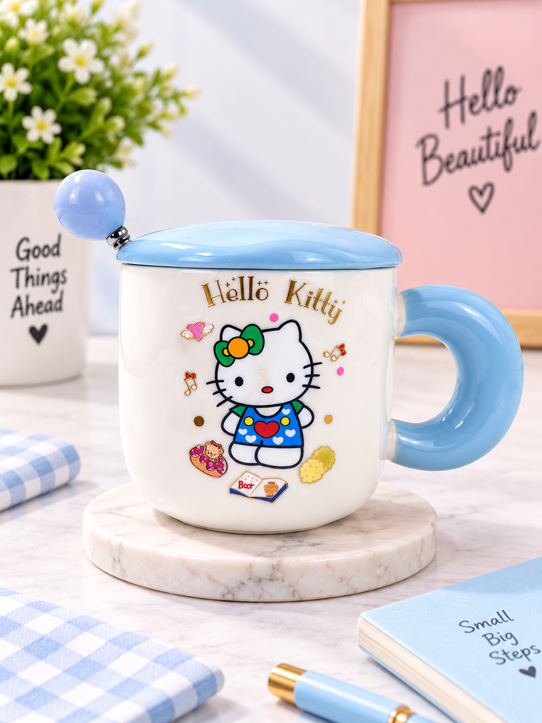Ceramic coffee mug with lid and spoon, white with Hello Kitty print, blue lid and handle.