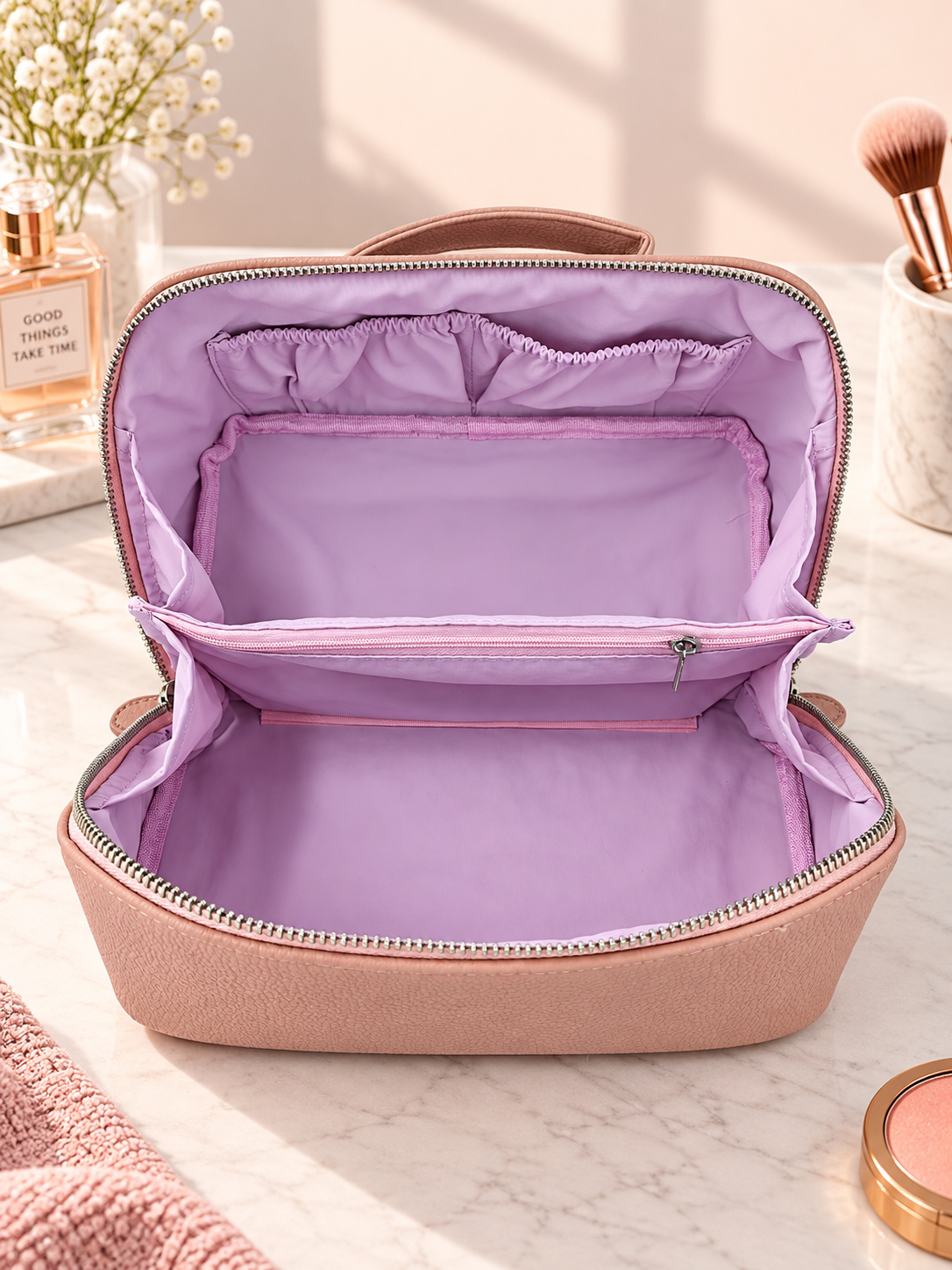 Open brown pebble-textured toiletry pouch with mauve lining, zipper top, and handle.