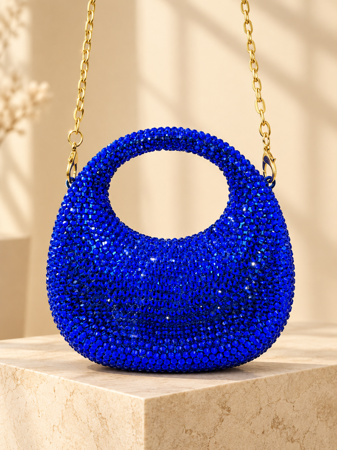 Blue crystal-encrusted circular evening handbag with gold chain handle