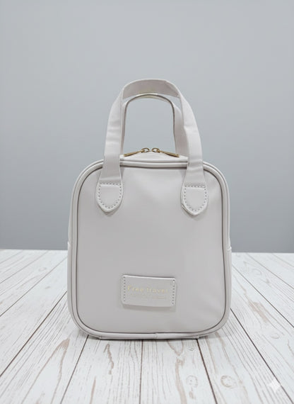 White leather-look makeup bag with top handle and front label pocket