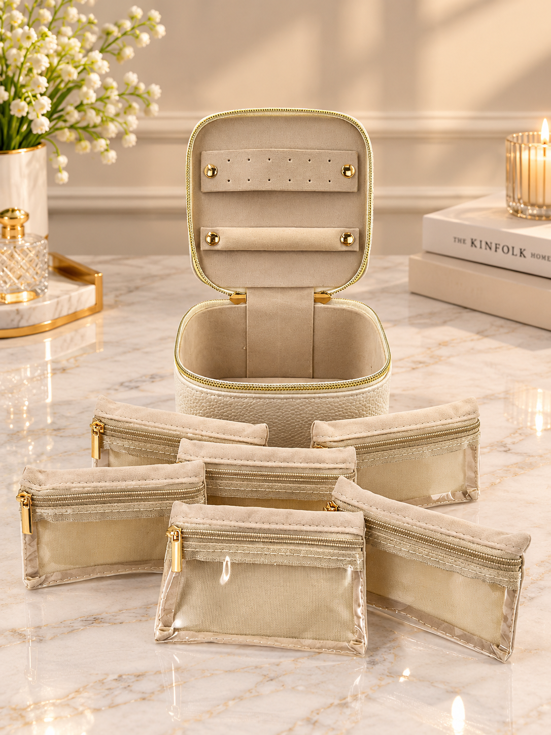 Cream jewelry organizer case with clear pouches, fold-out panels, and gold zipper hardware