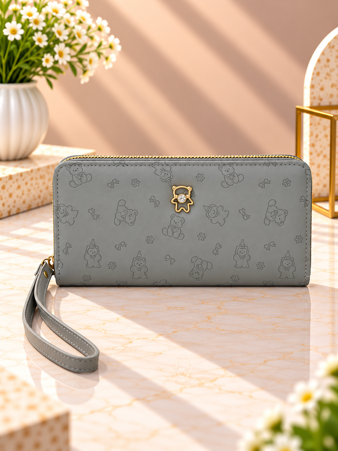 Gray zip-around wristlet wallet with debossed character pattern and wrist strap