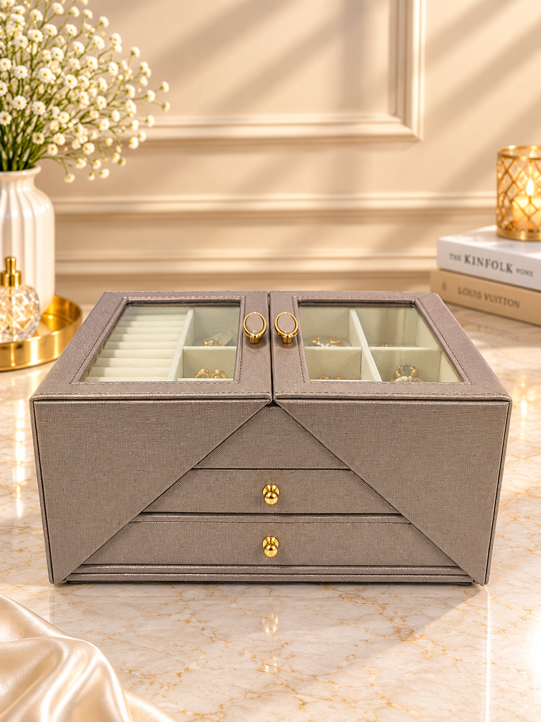 Taupe fabric jewelry storage cabinet with glass doors, open compartments and gold hardware
