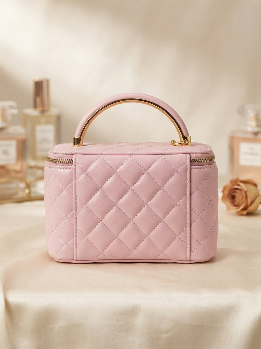 Pink quilted cosmetic case with metal handle and gold-trim zip-top closure