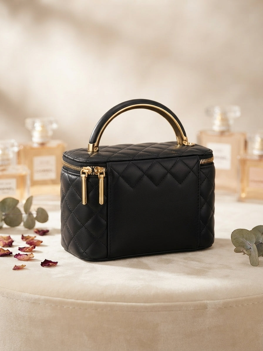 Black quilted vanity cosmetic case with metal handle and gold zipper accents