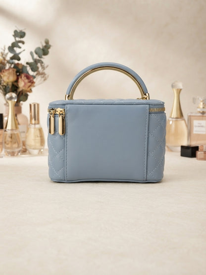 Blue quilted cosmetic case with metal handle and zip-top closure