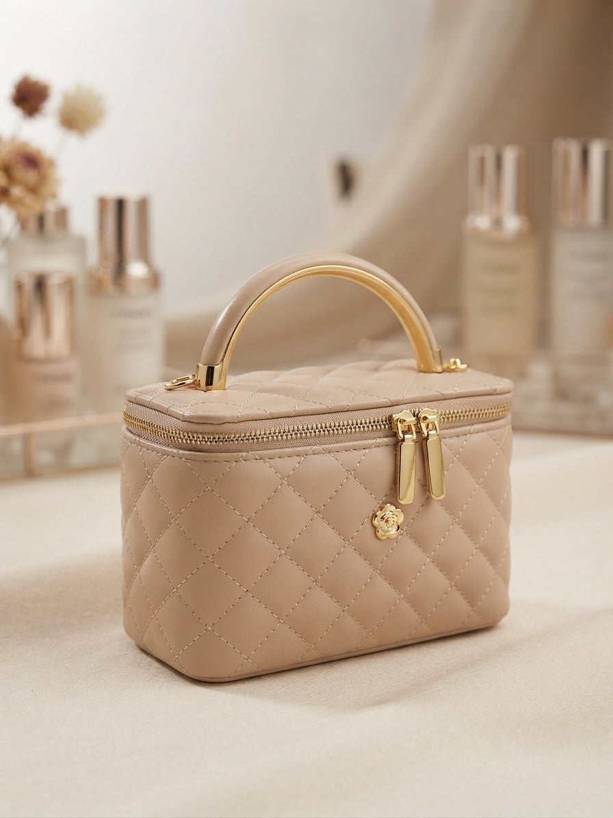 Quilted beige cosmetic case with gold handle and zipper, front emblem detail