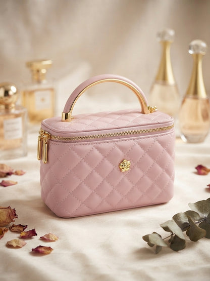 Light pink quilted vanity cosmetic case with metal handle, gold zipper, and emblem