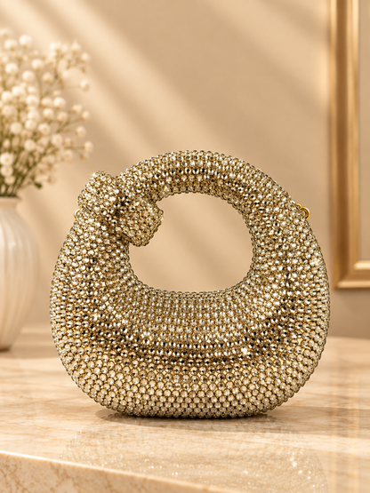 Gold crystal-encrusted crescent evening bag with knotted handle and chain strap