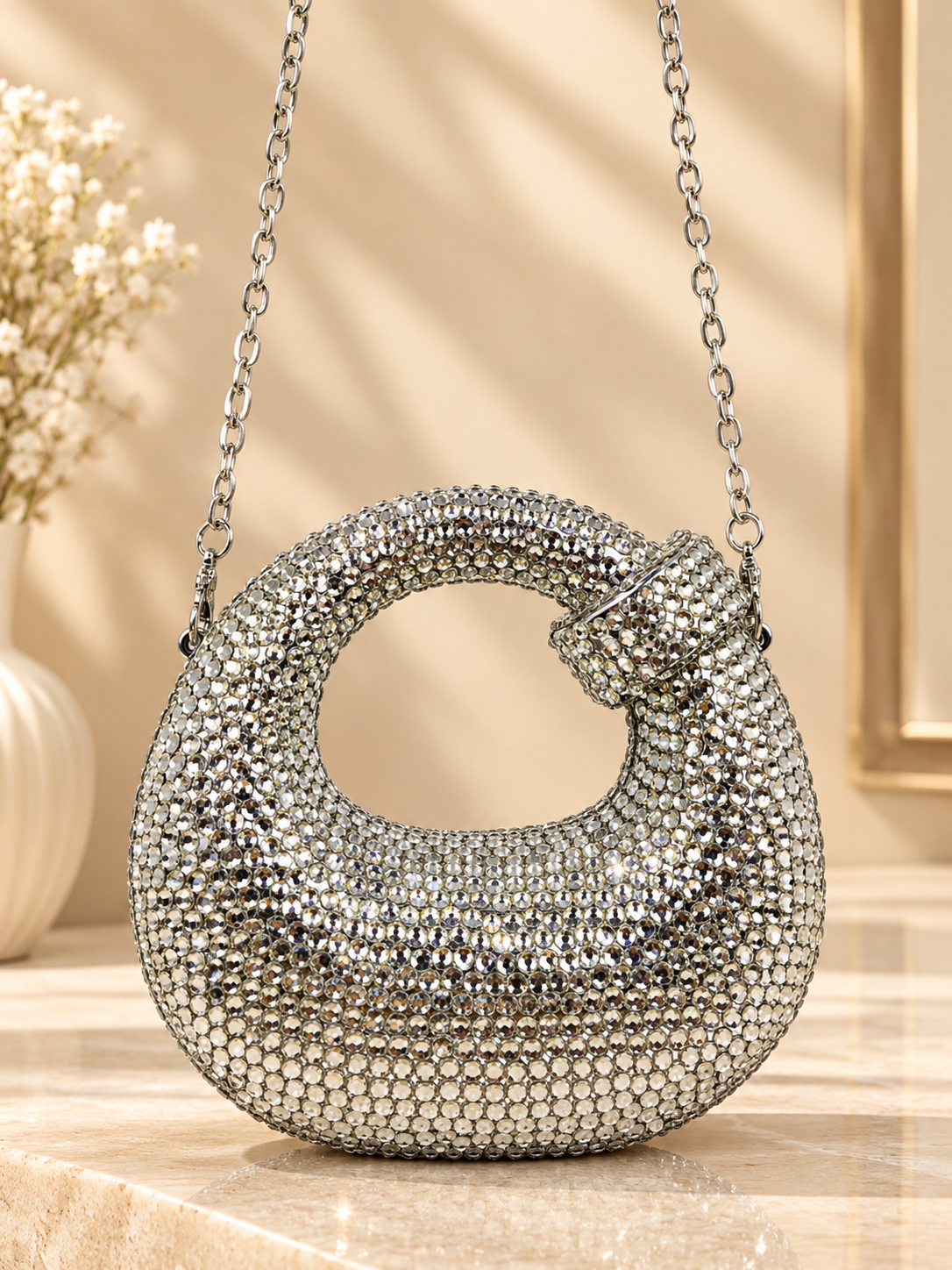 Silver crystal-encrusted crescent evening bag with knotted handle and chain strap