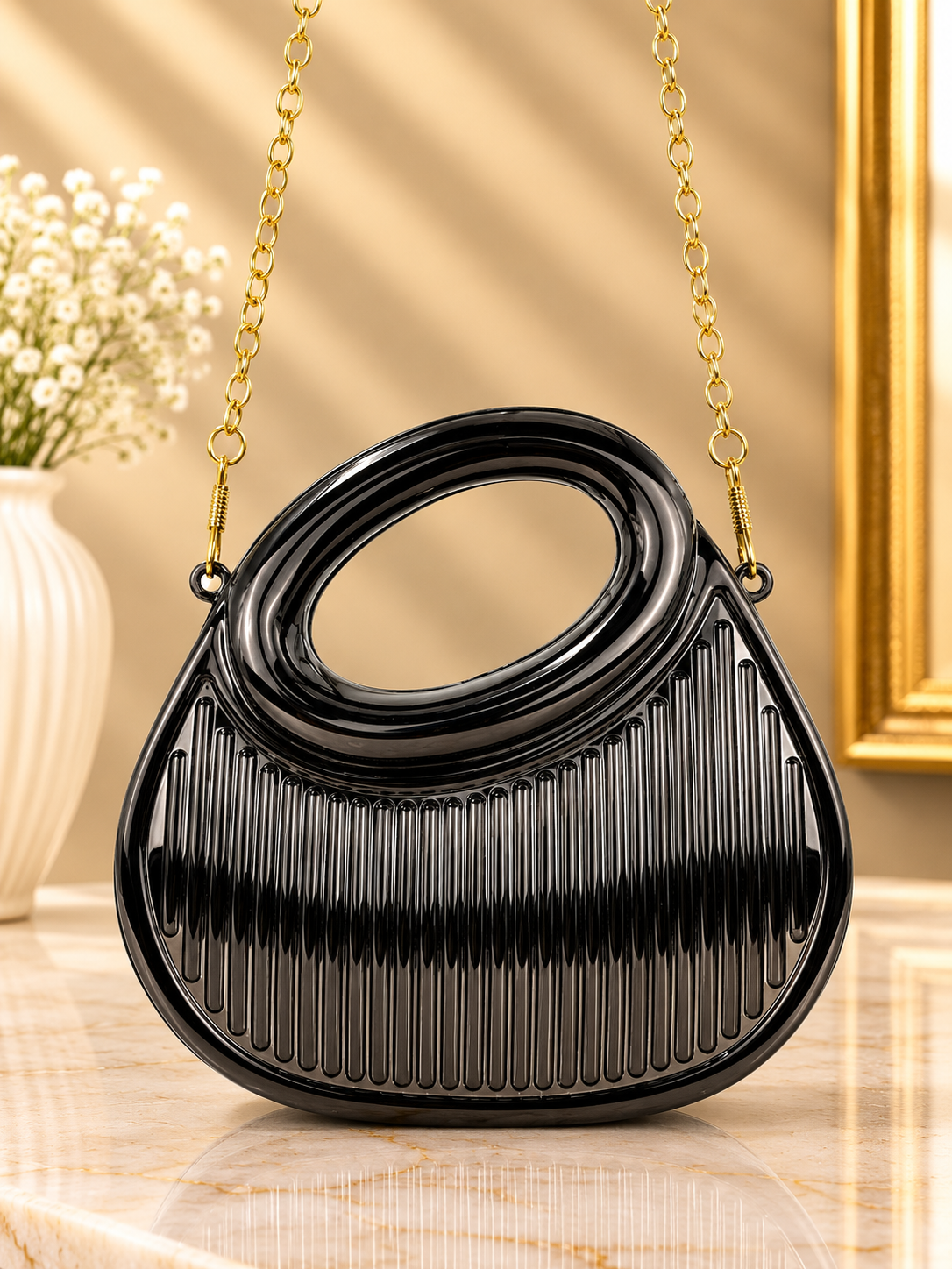 Black pleated metallic oval-handle evening handbag with gold chain strap and glossy trim
