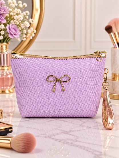 Purple pleated quilted cosmetic pouch with gold bow accent and wristlet strap, zip top