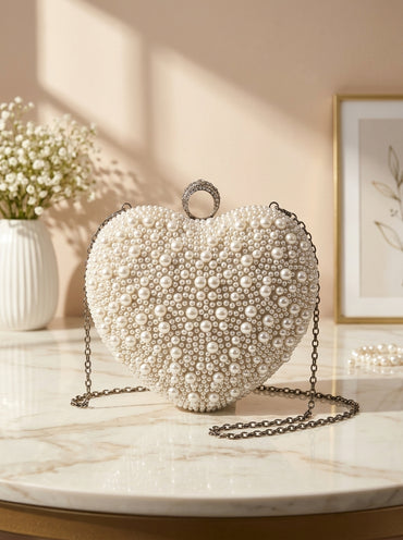 Heart-shaped pearl-embellished evening clutch with dangling chain strap