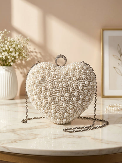 Heart-shaped pearl-embellished evening clutch with dangling chain strap