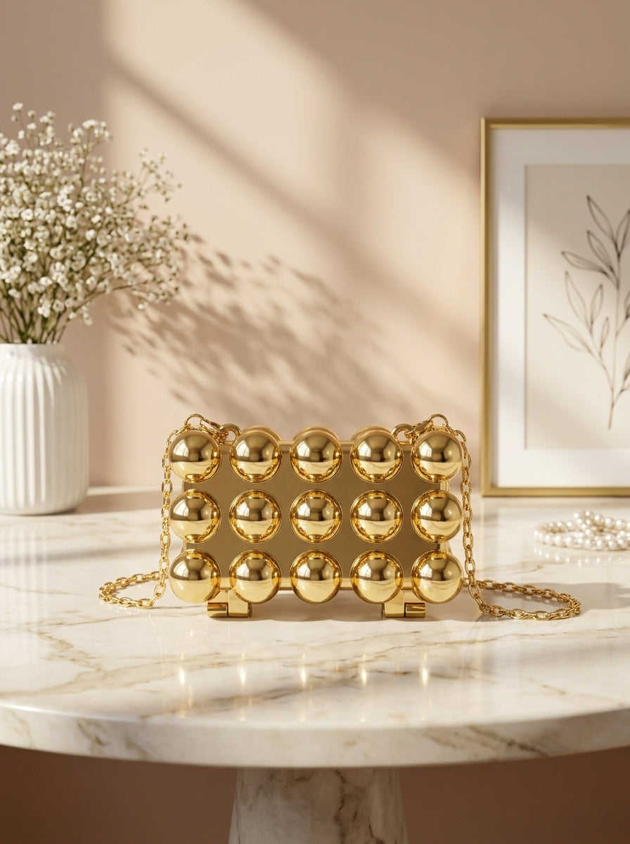 Gold bubble-studded spherical evening clutch with long chain strap