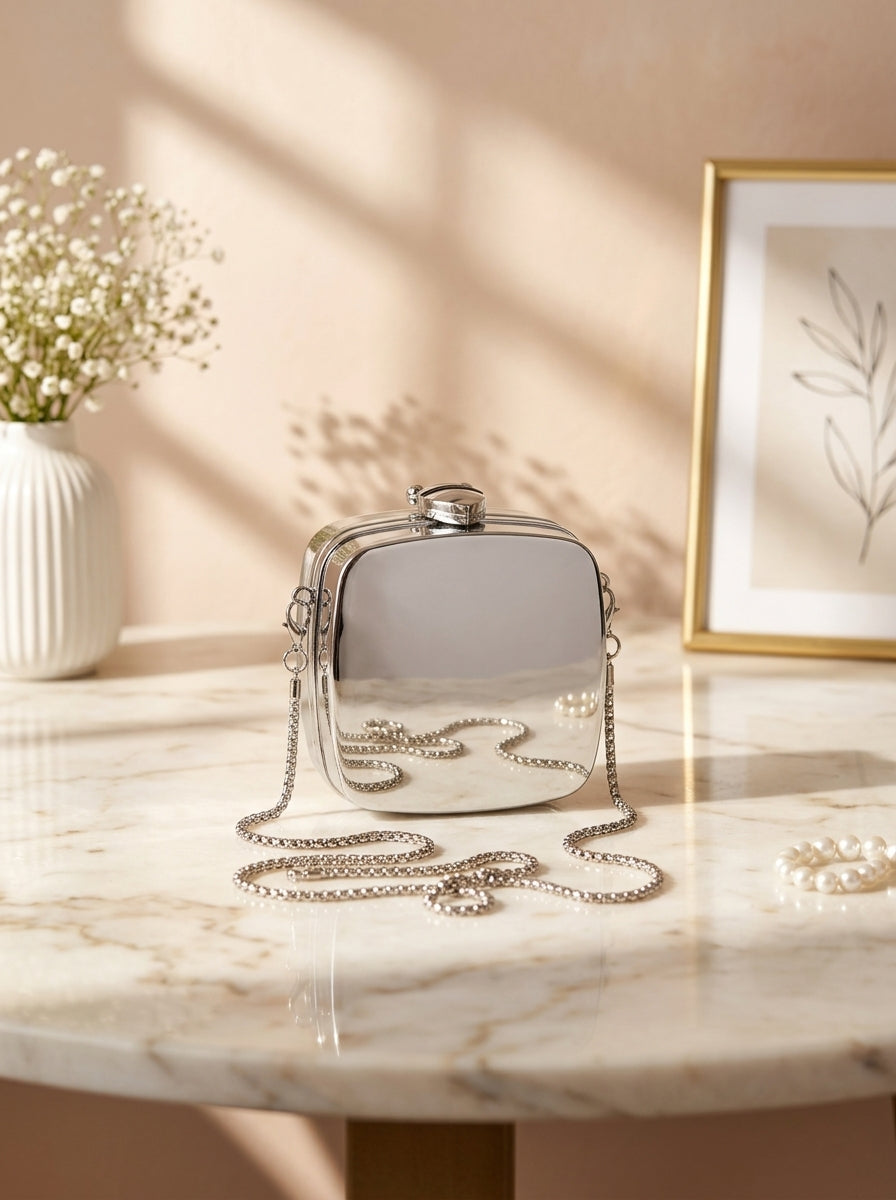 Silver metallic square box evening clutch with hinged lid and chain strap