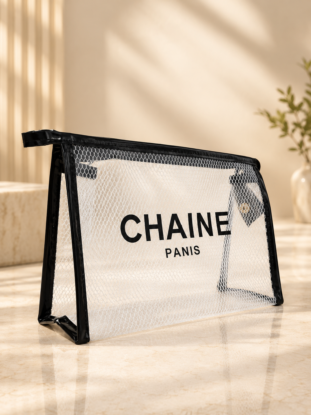 Black zip-top mesh cosmetic pouch with CHAINE Paris lettering, transparent front