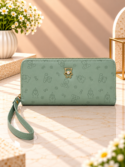 Green zip-around wristlet wallet with debossed character pattern and wrist strap