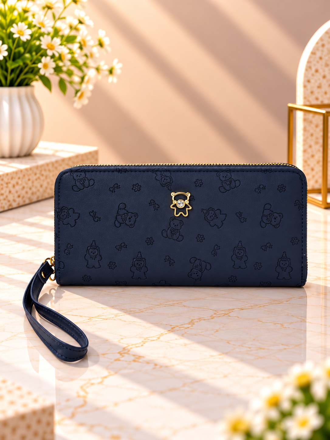 Navy blue zip-around wristlet wallet with debossed character pattern and wrist strap