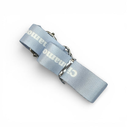 Light blue fabric bottle strap with metallic rings and partially visible text
