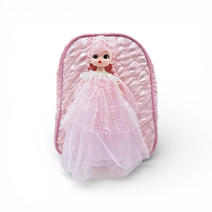 Pink doll in tulle dress inside quilted pink backpack, front view