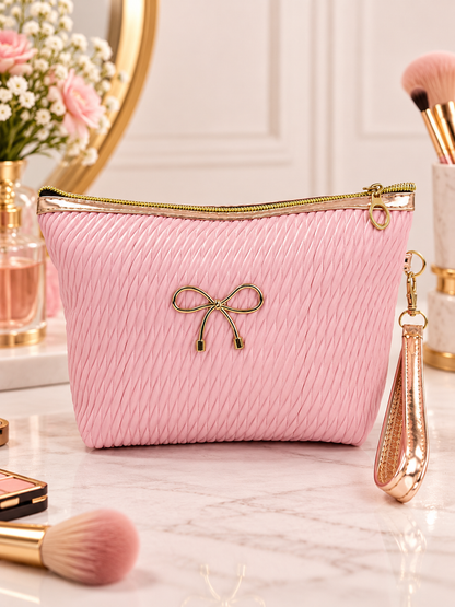 Pink pleated quilted cosmetic pouch with gold bow accent, zip top, wristlet strap