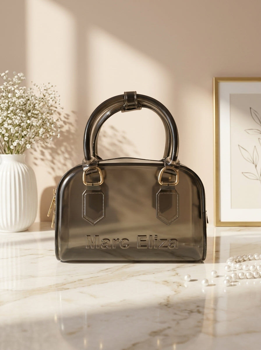 Dark jelly barrel handbag with top handles, zip closure, and Marc Eliza logo.