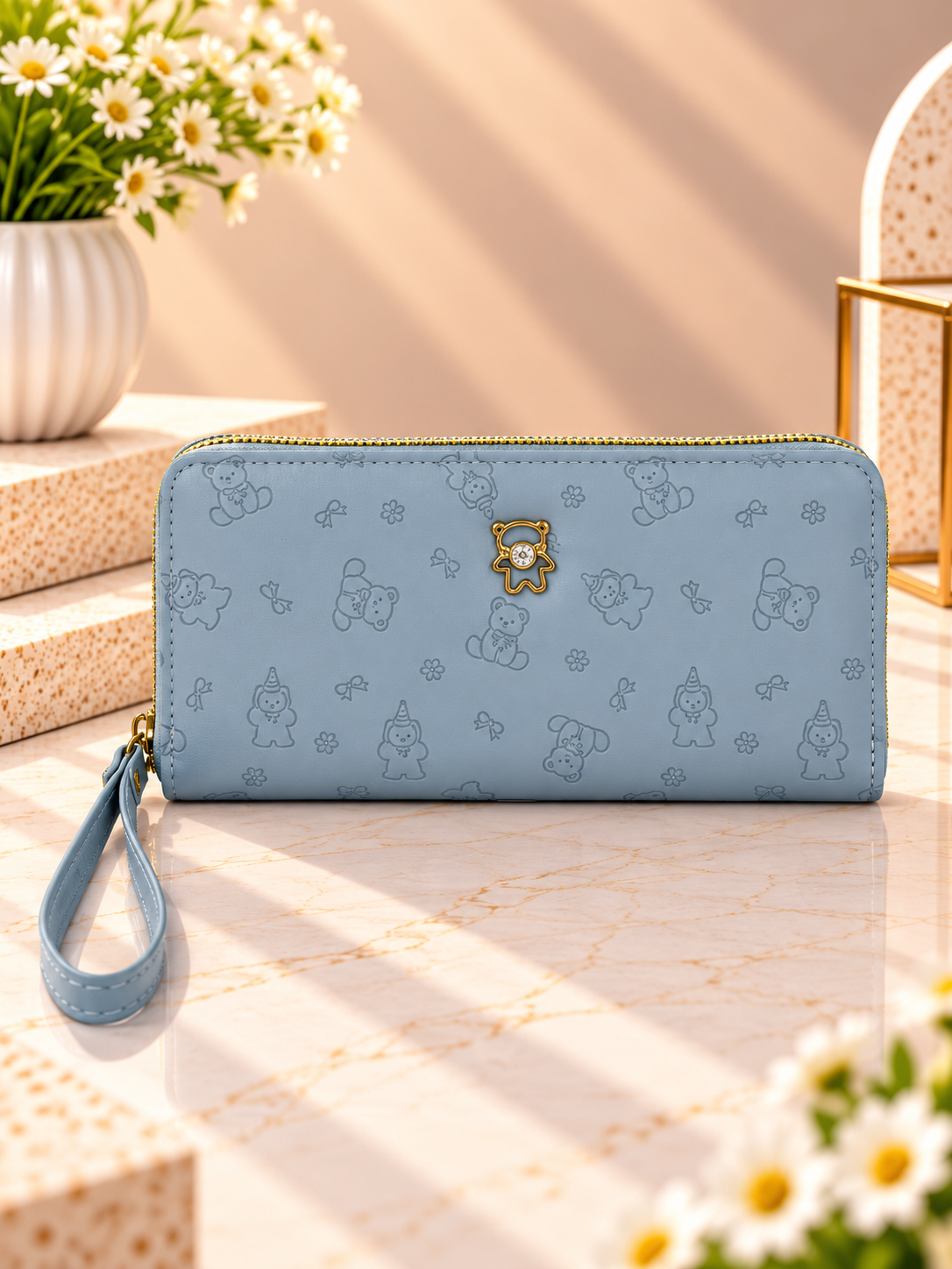 Sky blue zip-around wristlet wallet with debossed character pattern and wrist strap