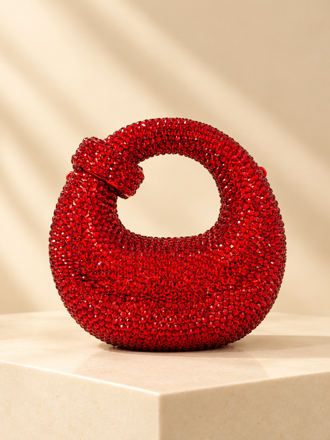 Red crystal-encrusted crescent evening bag with knotted loop handle