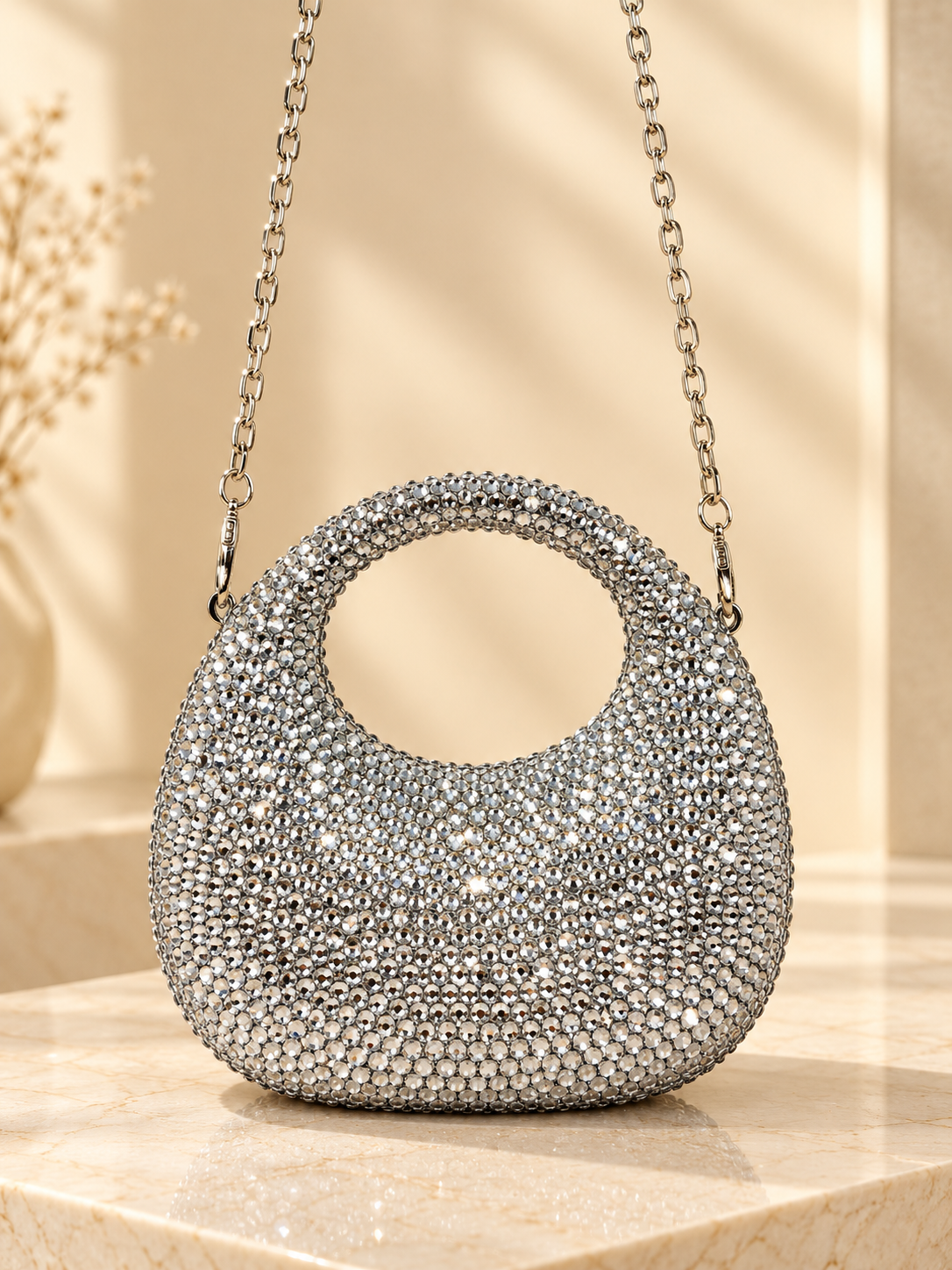 Silver crystal-encrusted circular evening handbag with gold chain handles