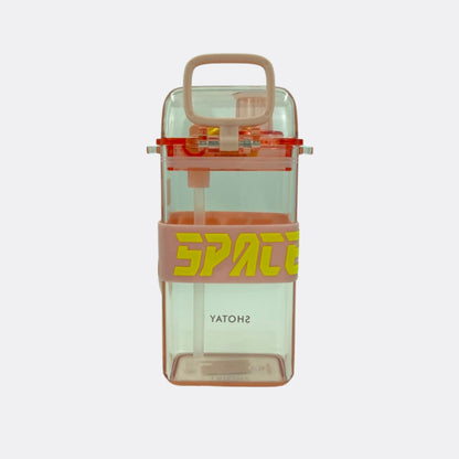 Clear transparent square water bottle with tan carry handle and orange SPATE strap.