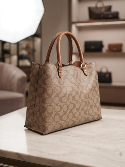 Structured tote bag in brown with repeating pattern, tan handles, gold-tone hardware