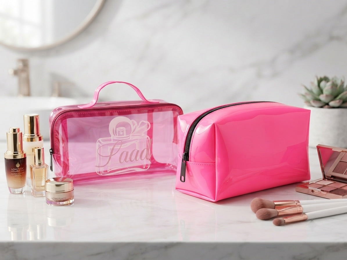 Pink clear cosmetic bag with top handle and matching pink zip pouch, side view.